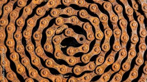 Rusty Bicycle Chain Coiled in Spiral Pattern Close Up Background