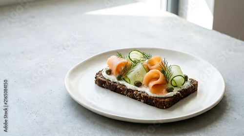 Fresh smoked salmon on rye bread with cucumber and lemon slices
