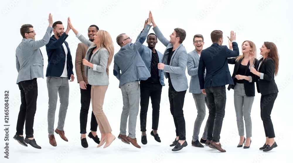 Fototapeta premium Diverse business team high fiving and jumping for joy in a professional studio setting