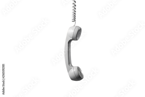 A white vintage telephone handset with a coiled cord hanging vertically, isolated against a solid black background, studio lighting, side view