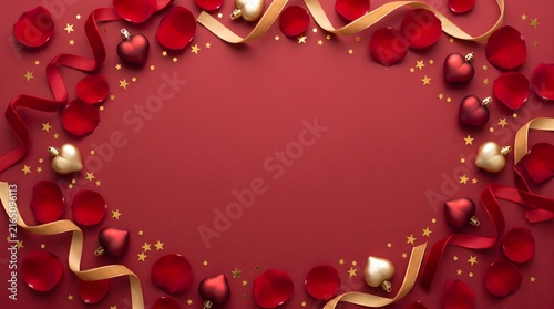 Red rose petals golden ribbons heart decorations forming a frame on red background with valentine background romantic
