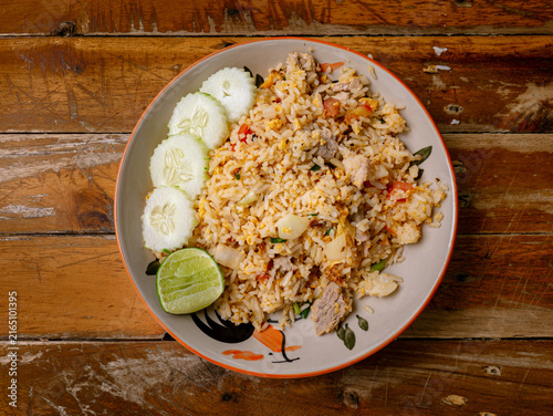 Foto Thai Pork Fried Rice with Cucumber Slices and Lime on Rustic Wooden Table, Homes