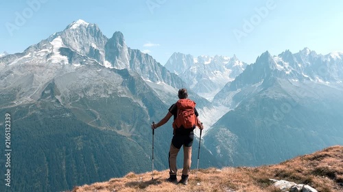 Hiker standing on mountain summit overlooking mont blanc range in france, Alps mountain
