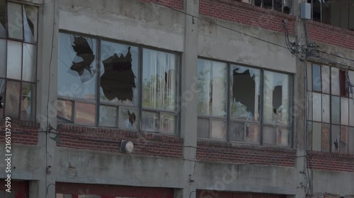 Shattered windows on the side of an abandoned warehouse. Destroyed factory. Industrial facility. 