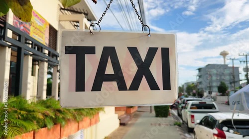 Homemade Taxi Sign Hanging From a Tree Branch on City Street