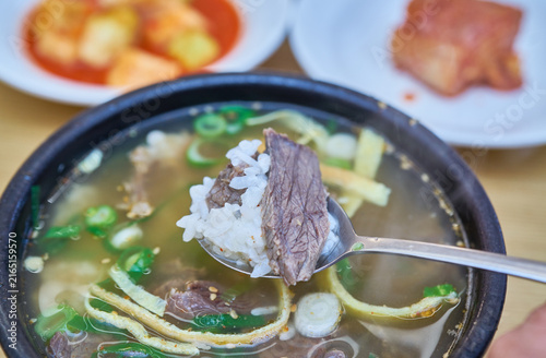 Fotografie Authentic regional clear beef soup with tender meat and egg garnish in earthen bowls