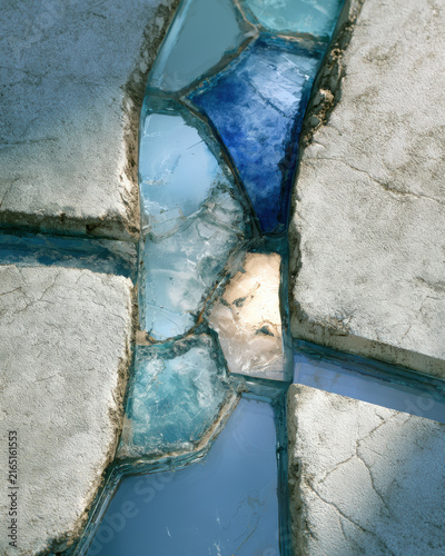 Blue glass shards gleam between cracked stone