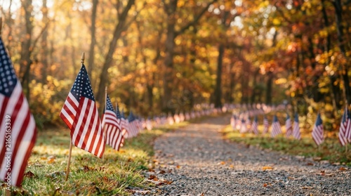 Veterans Day Row of small American flags lining a gravel forest path during autumn with beautiful golden hour sunlight and fall foliage USA