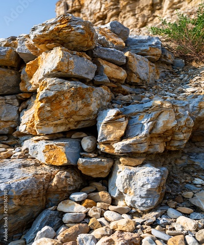 Layered sedimentary rock formations with warm sunlight and selective focus on a coastal cliffside