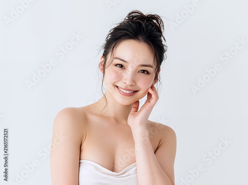 Obraz na płótnie 笑顔でスキンケアをする美しい日本人女性のビューティーポートレート白背景