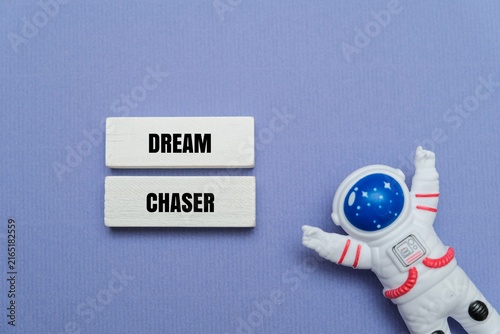 Foto Miniature astronaut upwards next text DREAM CHASER on a coloured background