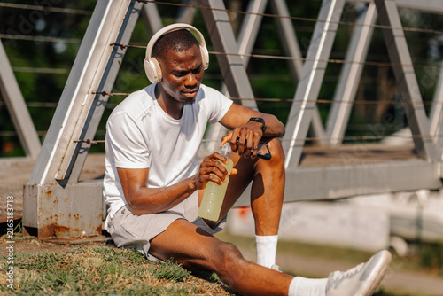 Fotografía African american man hydrating during outdoor workout break