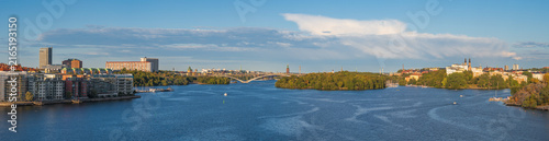 Wide panoramic view over riddarfjärden bay toward långholmen island and the västerbron bridge under a sunny summer sky, Stockholm, Sweden.