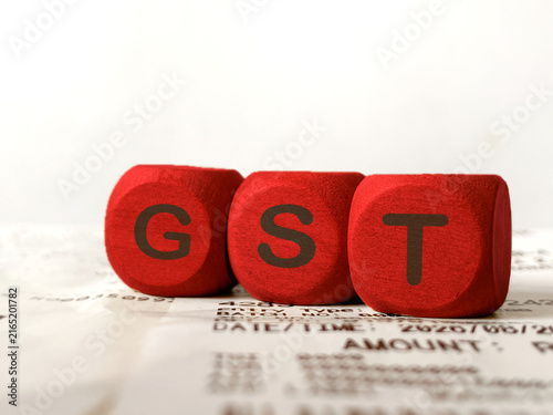 Foto GST Goods and Services Tax Concept with Wooden Blocks and Tax Document