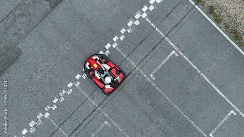 Fotografie Aerial view Go kart racer cross the finish line, Go kart at circuit start and finish line, Top view race go kart track