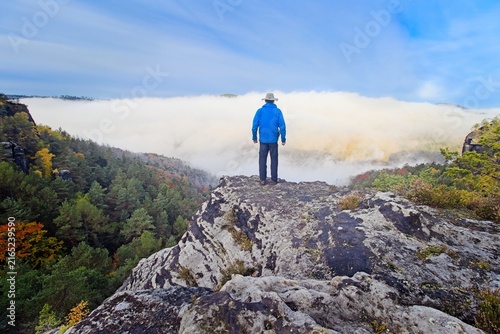 Foto A lonely man stands on a sandstone rock overlooking the autumn inverse fog Cover