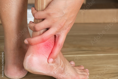 Ankle pain showing a man holding his ankle due to discomfort for specialized medical treatment and Achilles tendon injury illustration.