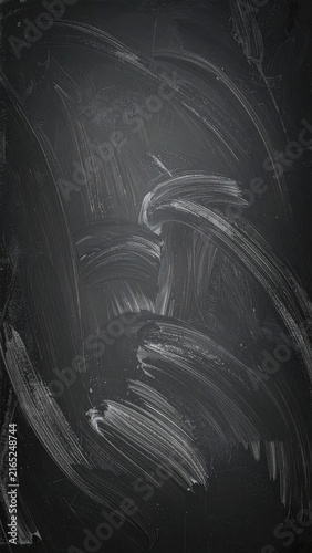 A dark, textured background resembling a wiped chalkboard with visible chalk marks.