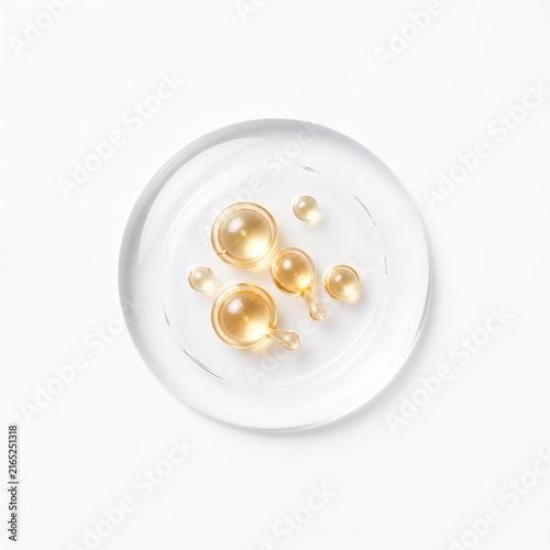 Top-down view of golden peptide micro capsules suspended in crystal clear serum droplet