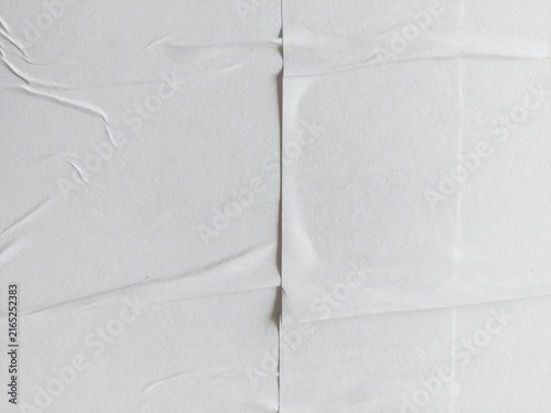 Abstract white crumpled paper poster background with soft surface texture. Blank white paper poster with creased and wrinkled surface. Crushed and creased soft paper texture background.
