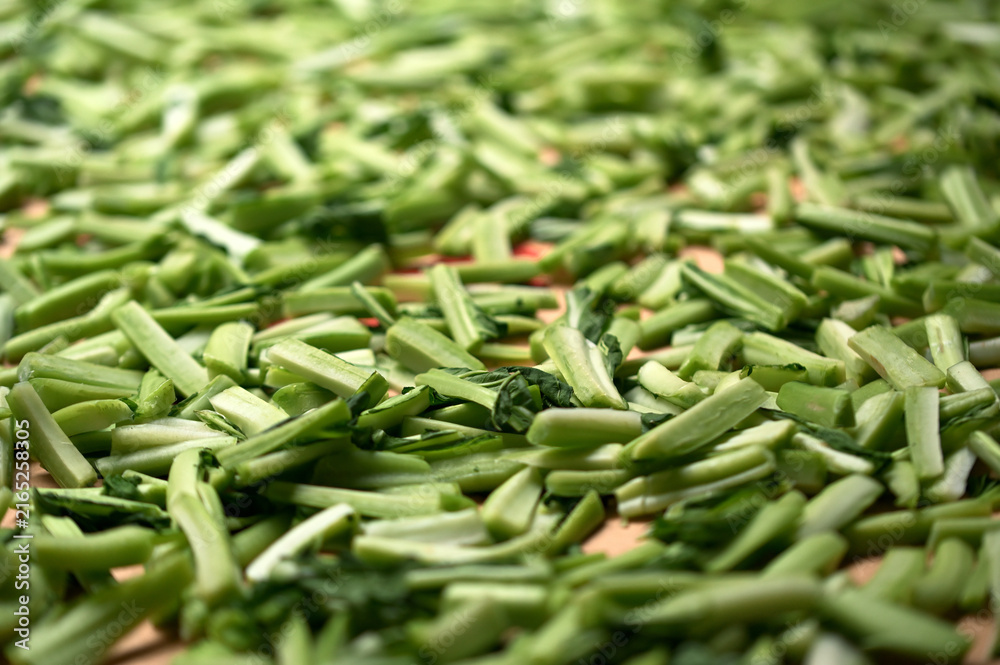 Fototapeta premium Mustard greens cut into strips cover a timber board, natural cut marks on the stems, Huaxin Street, Zhonghe District, New Taipei City, before sun-drying.