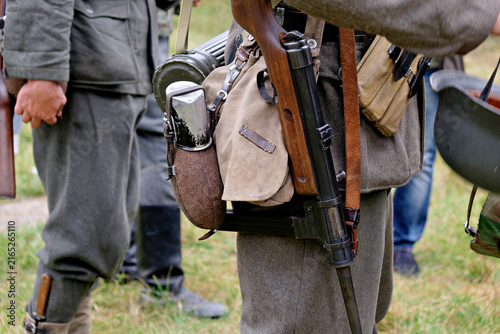 Canvastavla Close up shot of historical military equipment featuring a vintage submachine gun attached to shoulder strap, canteen, and leather belt pouches