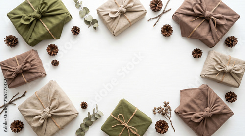 Top view flat lay of earth-tone Furoshiki wrapped gifts and pinecones.