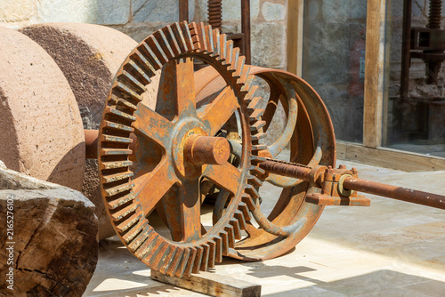 Foto Close-up shot of an antique rusty metal cogwheel mechanism paired with large stone grinding millstones on display in a historical setting