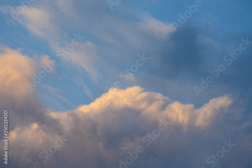 Majestic sun rays beaming upward behind clouds against dramatic blue sky