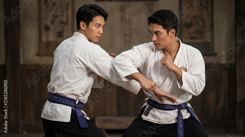 Two Asian men fight in martial art tournament