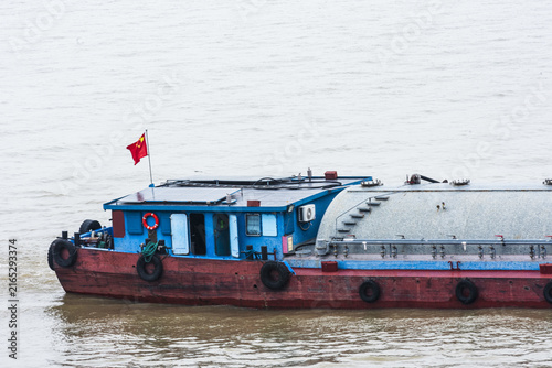 Photography Small commercial cargo barge underway on the Yangtze River in the Shanghai area, representing inland waterway transportation and the movement of goods along one of China’s major rivers