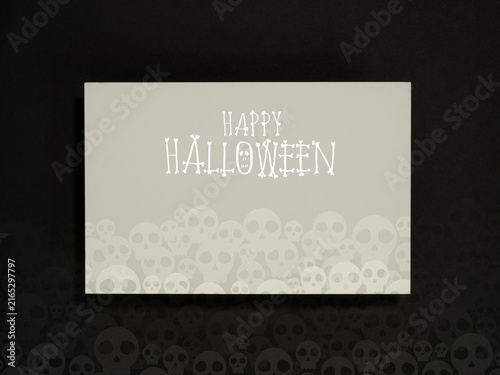 Happy Halloween greeting card featuring spooky white typography and layered skull illustrations on dark background. Party invitations, event banners, social media posts, and seasonal promotions.