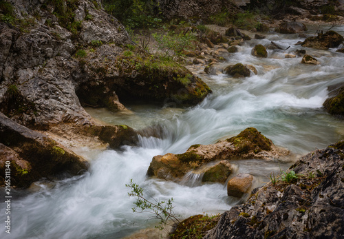 Rushing mountain stream flowing over rocks in nature