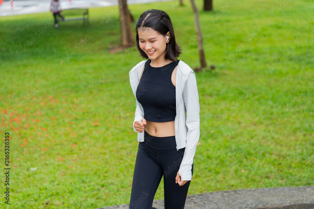 Fototapeta premium Asian sporty woman running in public park