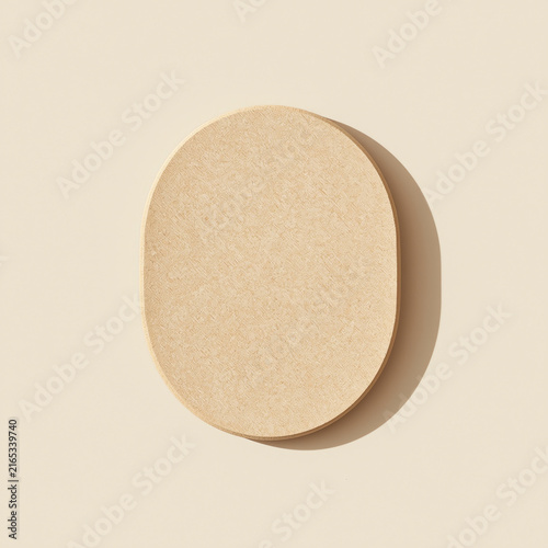 A close-up view of a beige makeup sponge on a neutral background
