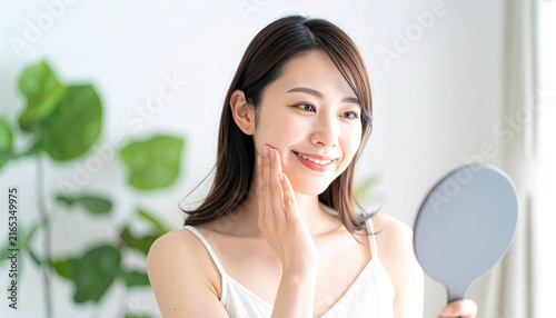 Plakat 手鏡で自分の肌の状態をチェックし微笑むキャミソール姿の女性（スキンケア・デイリーケア）