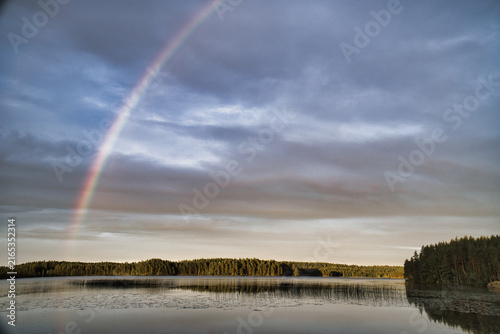Luminous Rainbow Over Calm Forest Lake