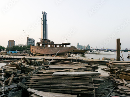 Konstfotografi Traditional wooden dhow boats in industrial waterfront fence in Dubai Creek