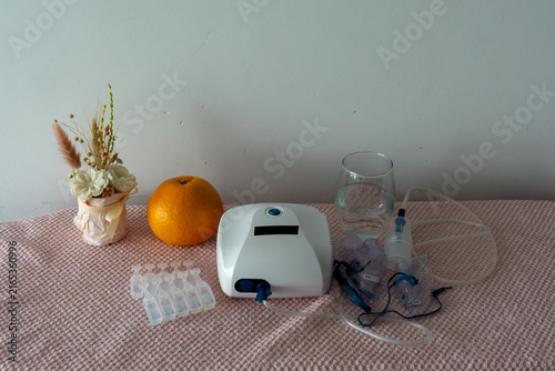 Quadro su tela Nebulizer machine with inhalation mask, tubing and saline ampoules prepared for respiratory therapy at home
