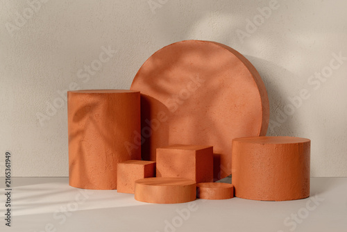 Natural Product Presentation Scene made with Multiple Terracotta Cylinder Podiums and Leaf Shadow on Neutral Background