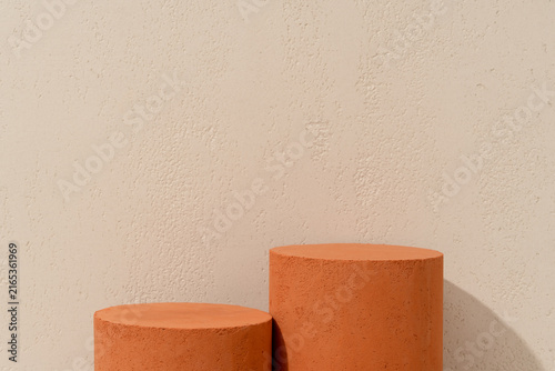 Prodcut Presentation Scene made with Two Terracotta Cylinder Podiums of Different Heights on Beige Travertine Background