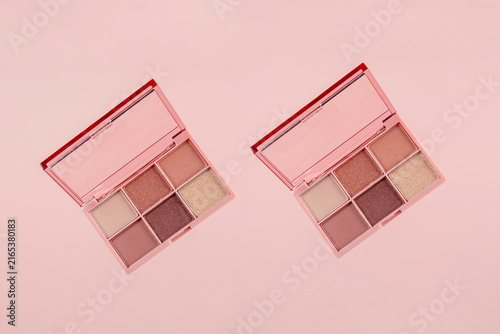 Eyeshadows palette in brown and purple shades on pink background