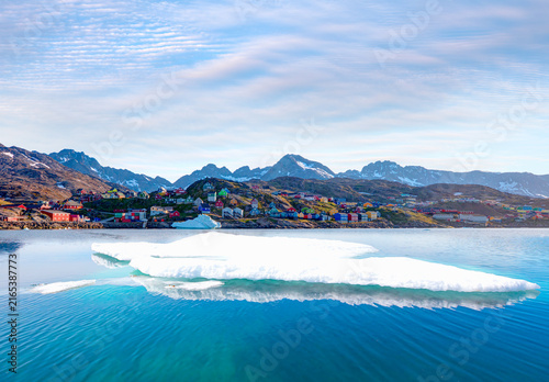 Melting icebergs by the coast of Greenland, on a beautiful summer day - Picturesque village on coast of Greenland - Colorful houses in Tasiilaq, East Greenland