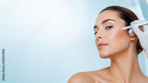 Woman receiving cosmetic treatment with dermal filler injection on face for skin enhancement