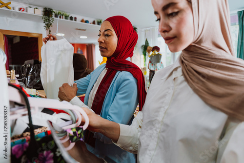 Quadro su tela Muslim women shopping for clothes in retail store