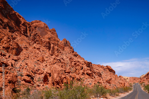 Scenic asphalt highway winding through dramatic red rock formations in Valley of Fire State Park, Nevada road trip.