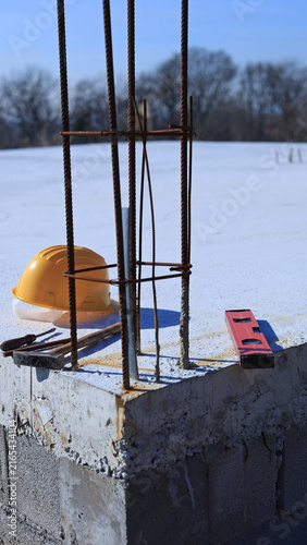 Foto Construction tools and helmet on a cement foundation with iron rebar