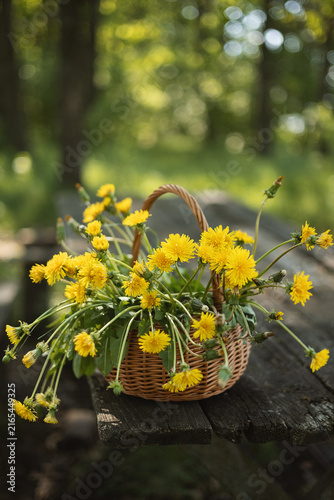 A photo of a bouquet of dandelions in a basket.