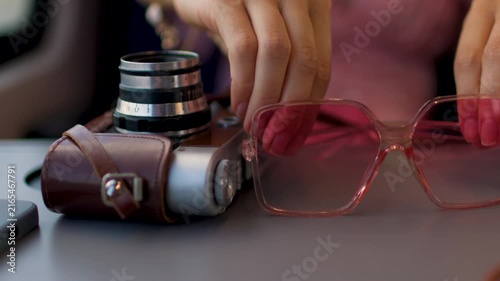Traveling by train. A girl puts pink sunglasses on the table in the train next to the camera. The mood of summer travel. interior of the train carriage