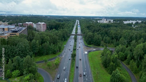 Cinematic aerial drone footage over a highway in Helsinki, Finland, on a cloudy, rainy summer day